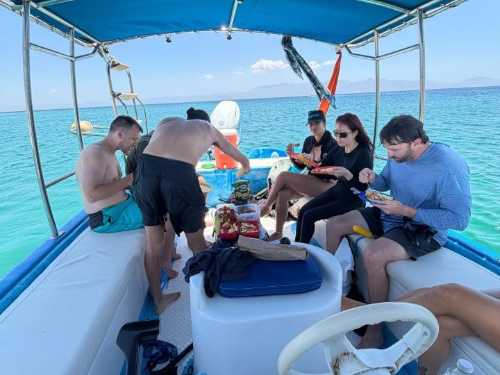 Viajeros compartiendo comida a bordo de la lancha durante un safari